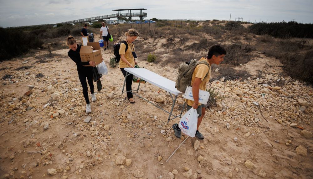 Los participantes llevan los materiales hasta la playa.