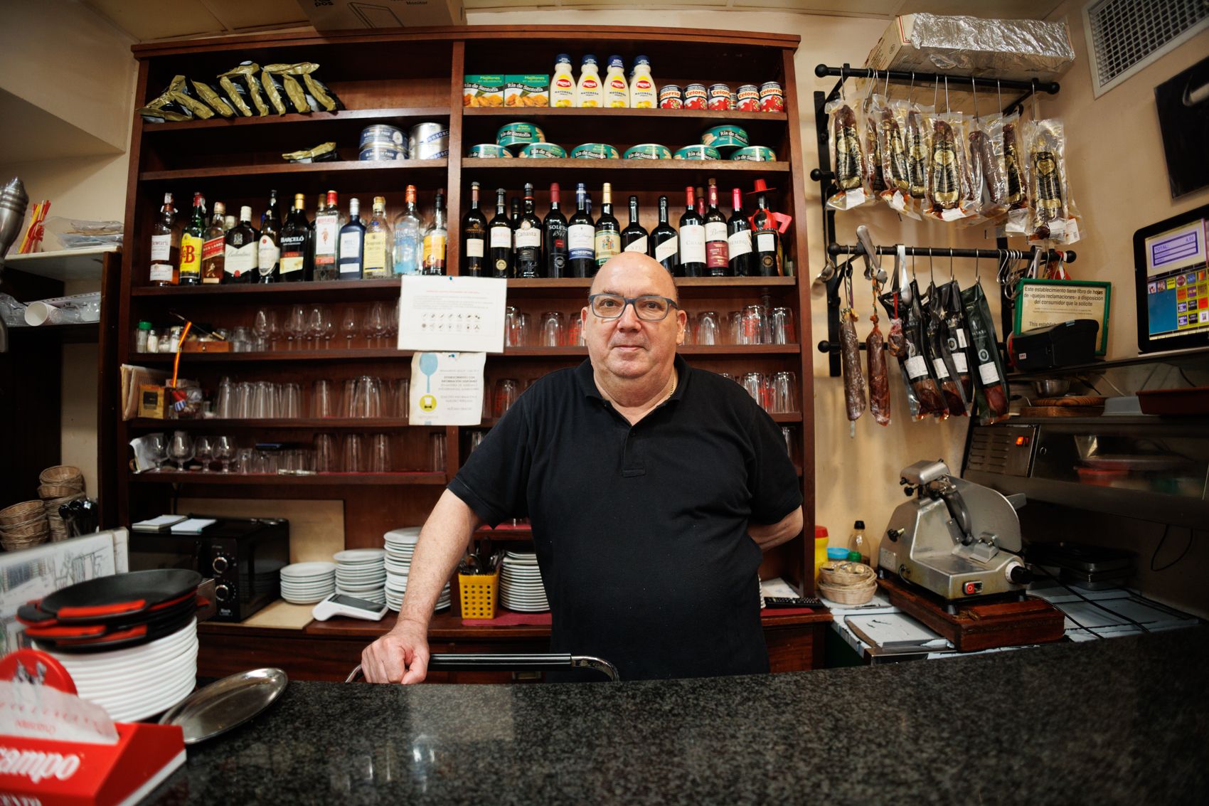 Juan detrás de la barra de su bar. 