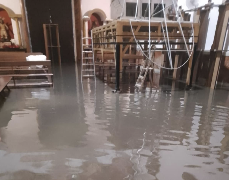 El interior de la iglesia de la Victoria inundada con la mesa del palio al fondo.