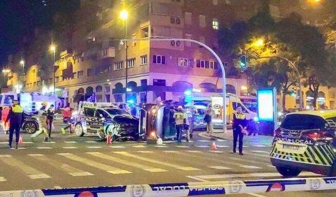 La furgoneta, volcada tras chocar con el coche de la Policía Local de Sevilla.