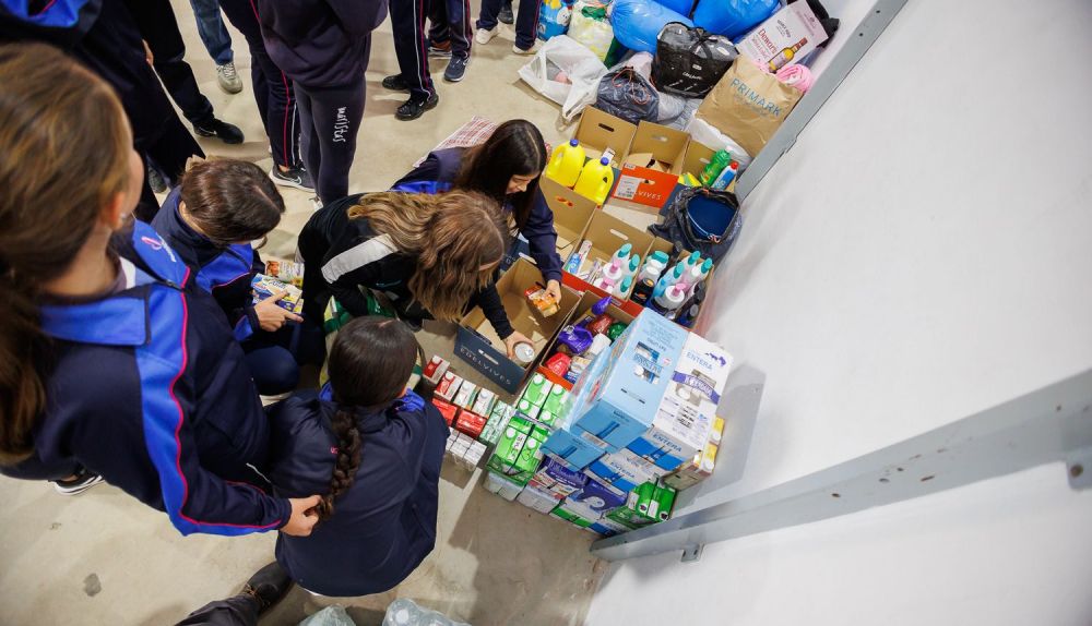 Los alumnos y alumnas ordenan el material que entregan las familias.