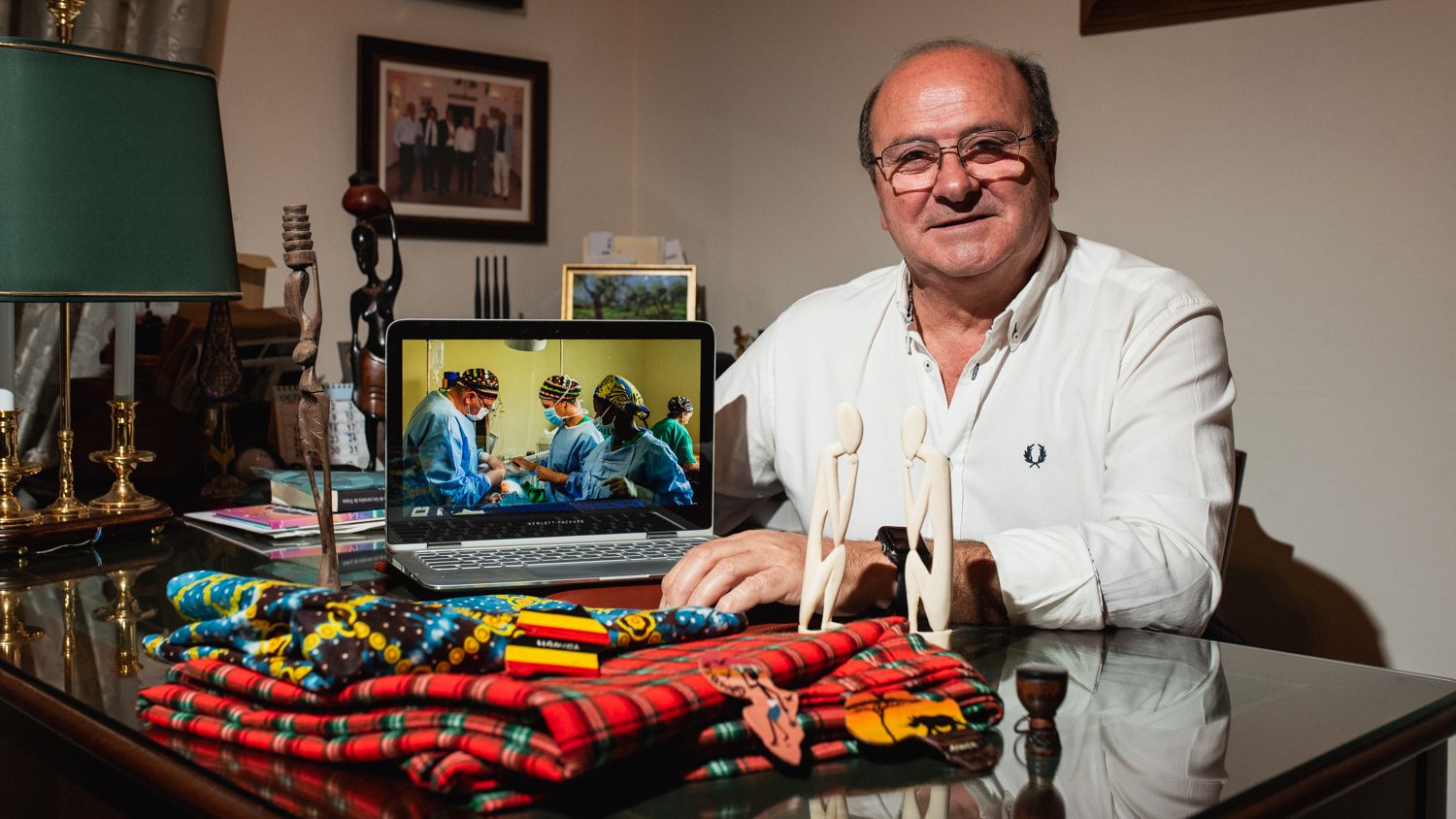 Manuel Bustos posa en su despacho ante una foto de una de sus campañas y ropa típica del continente negro.