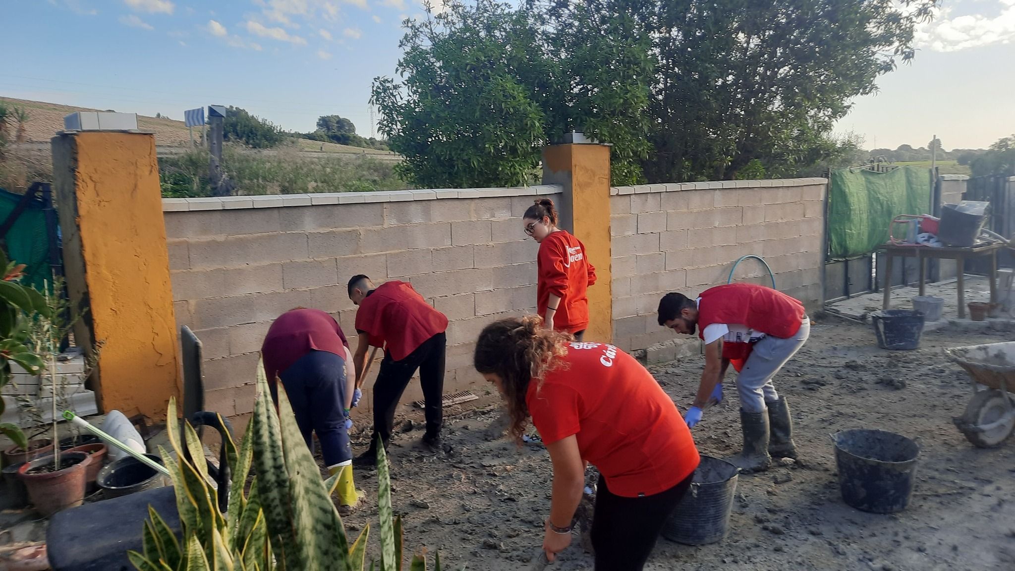 Unos jóvenes ayudan a una vecina afectada por las inundaciones de la DANA.