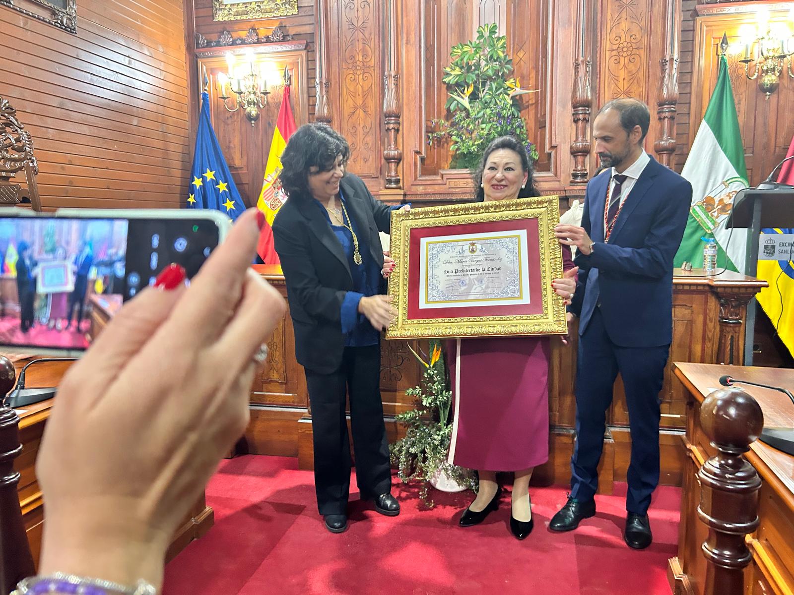 La alcaldesa entregando el título de Hija Predilecta de Sanlúcar a María Vargas.