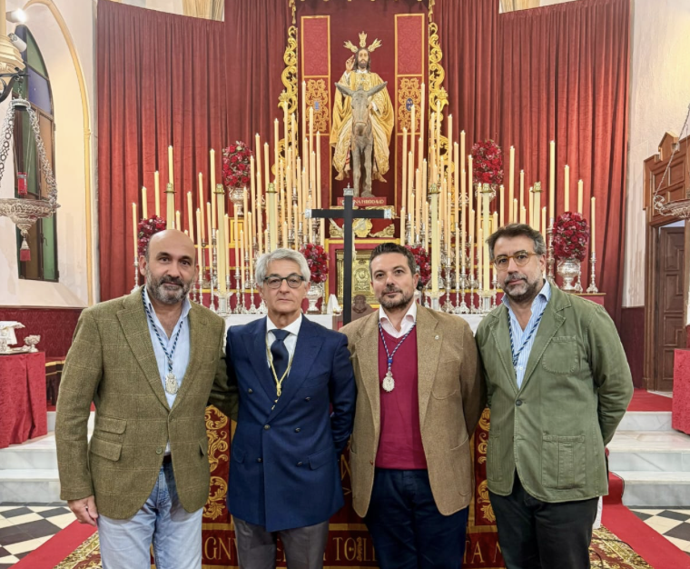 El hermano mayor y los capataces nombrados ante el altar de cultos de Cristo Rey. 