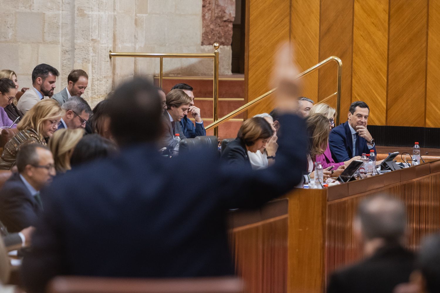 Juanma Moreno, al fondo, mira a José Ignacio García, de Adelante, durante su intervención en el debate del Parlamento andaluz.