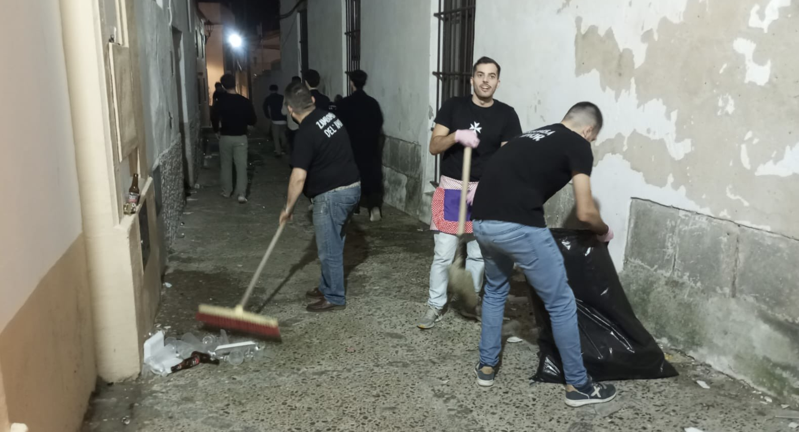 Un grupo de hermanos del Cristo del Amor, limpiando una calle tras la Zambomba de la referida hermandad.