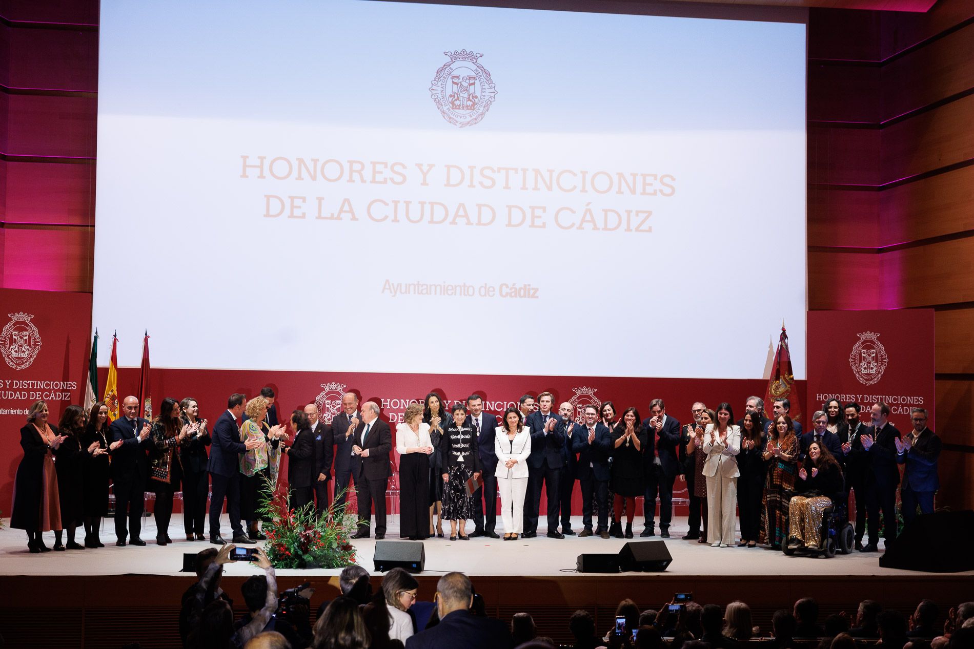 Los Hijos Adoptivos y Predilectos de Cádiz y las autoridades, con la viuda de Carlos Díaz en el centro, en el Palacio de Congresos.