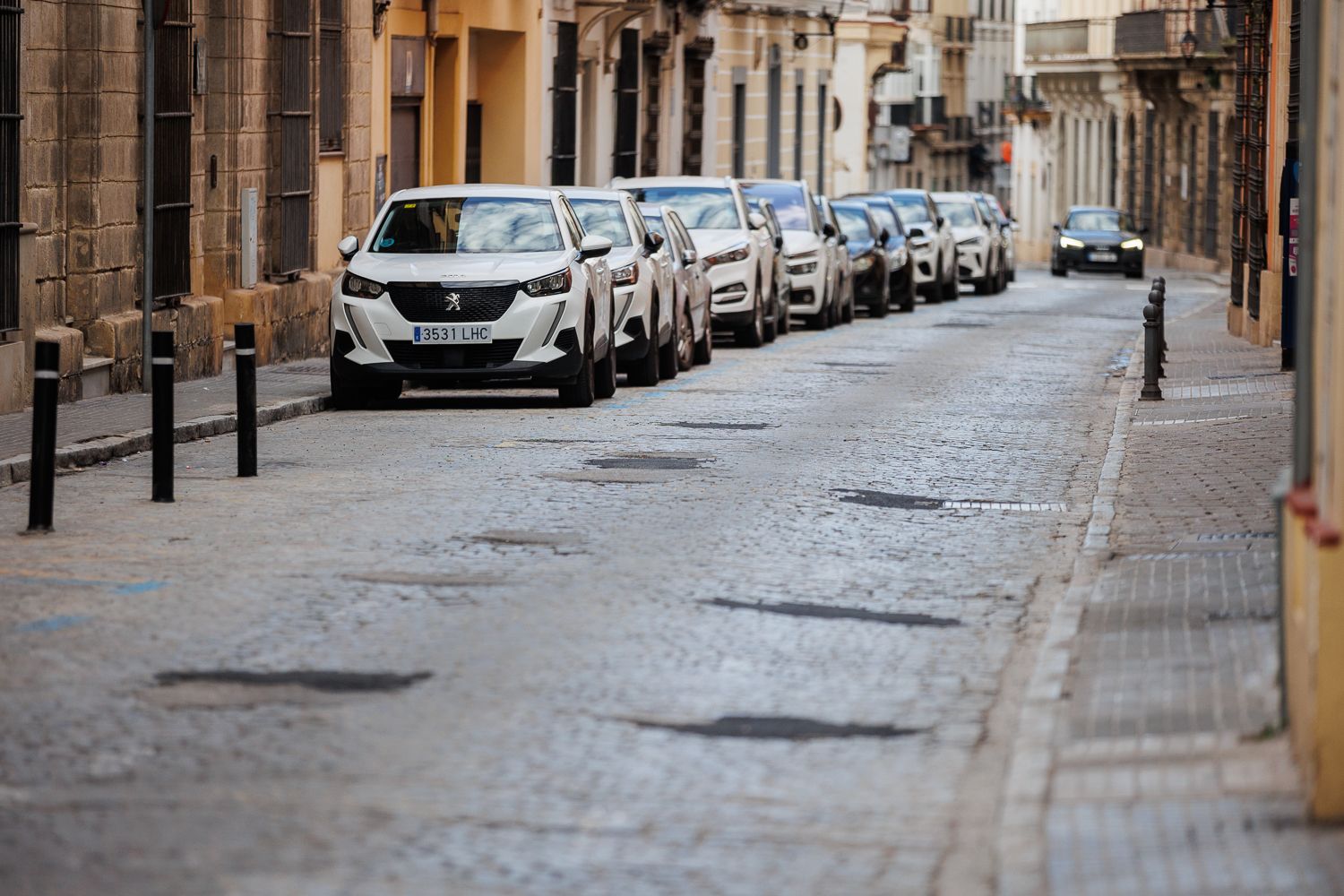 Con baches y parches, así está la calle Caballeros de Jerez.