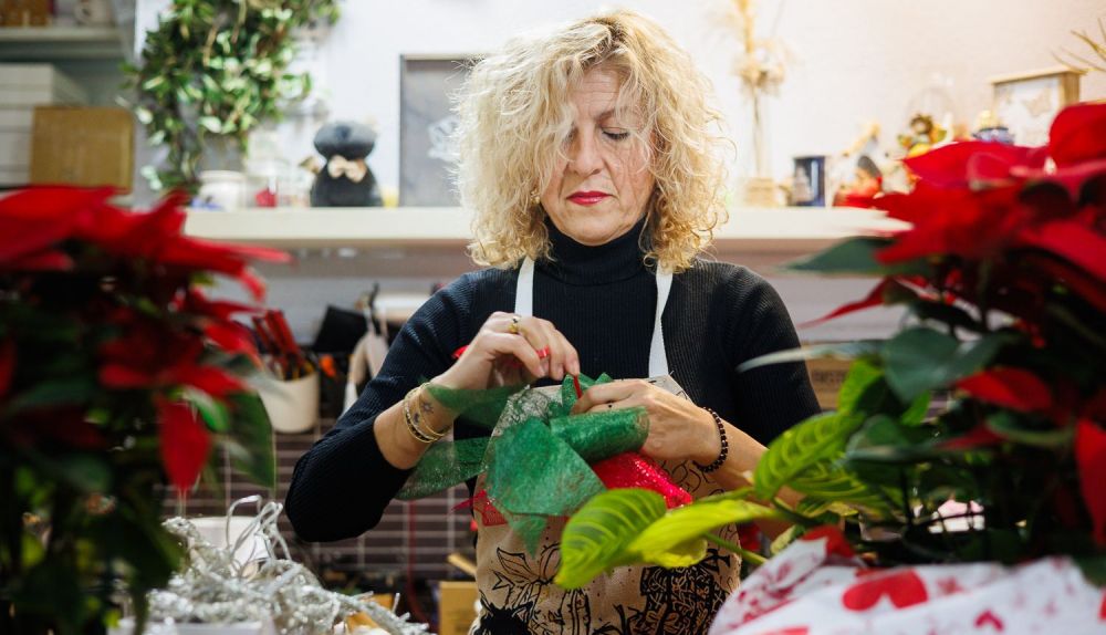 La florista prepara un ramo en su tienda.