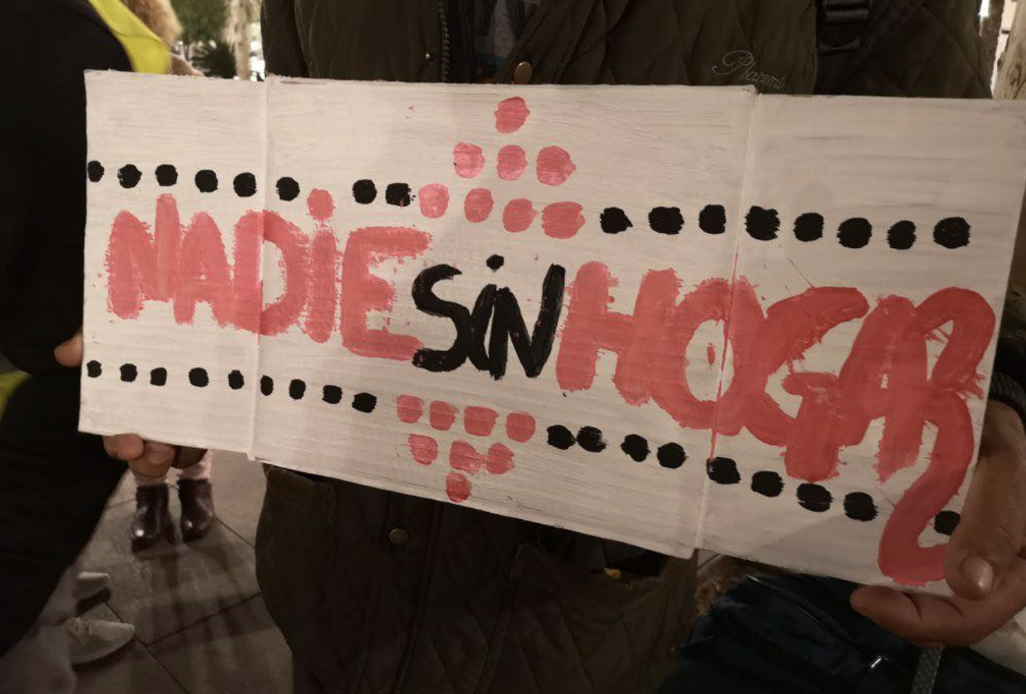 Una persona muestra un cartel con una clara reivindicación: "Nadie sin hogar".