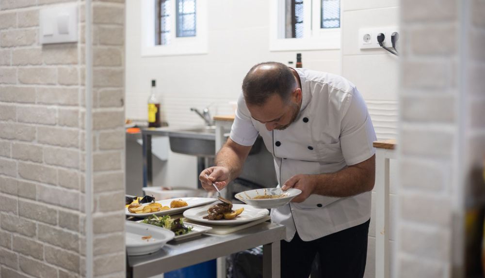 Manuel Vargas en la cocina preparando un plato.