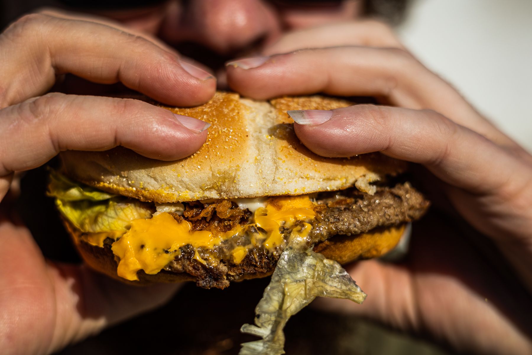 Una persona comiendo una hamburguesa, en una imagen de archivo. 